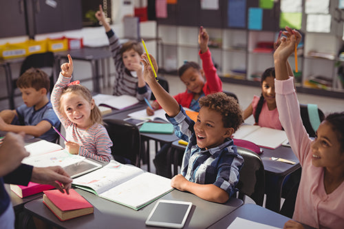 Classroom with Children Raising Hands