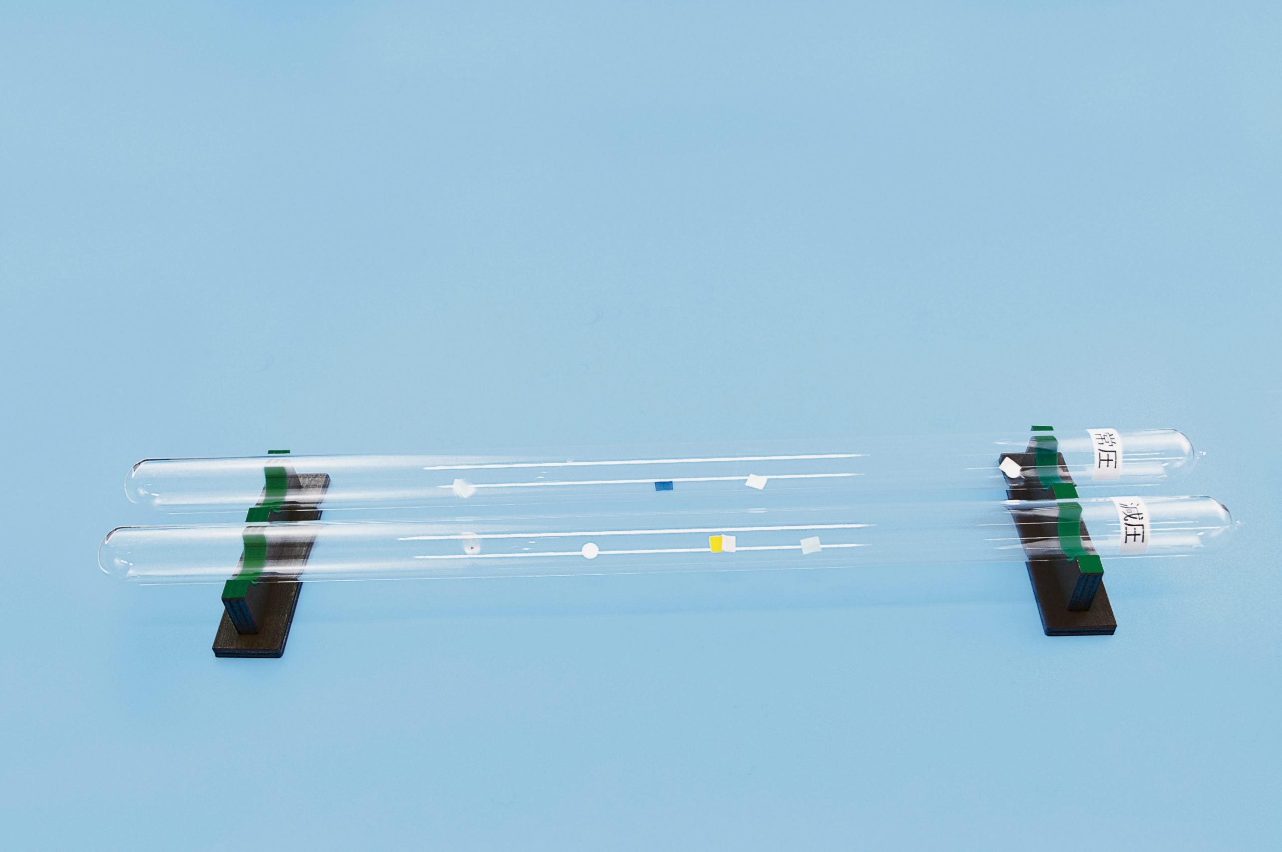 Free Fall Tubes. A set of 2 glass tubes under a vacuum that contain pieces of a feather, paper, and metal. Size 40 x 750mm. Made by Narika Corporation.